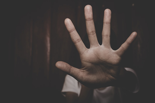 Image of a hand signal to stop the act of coercion