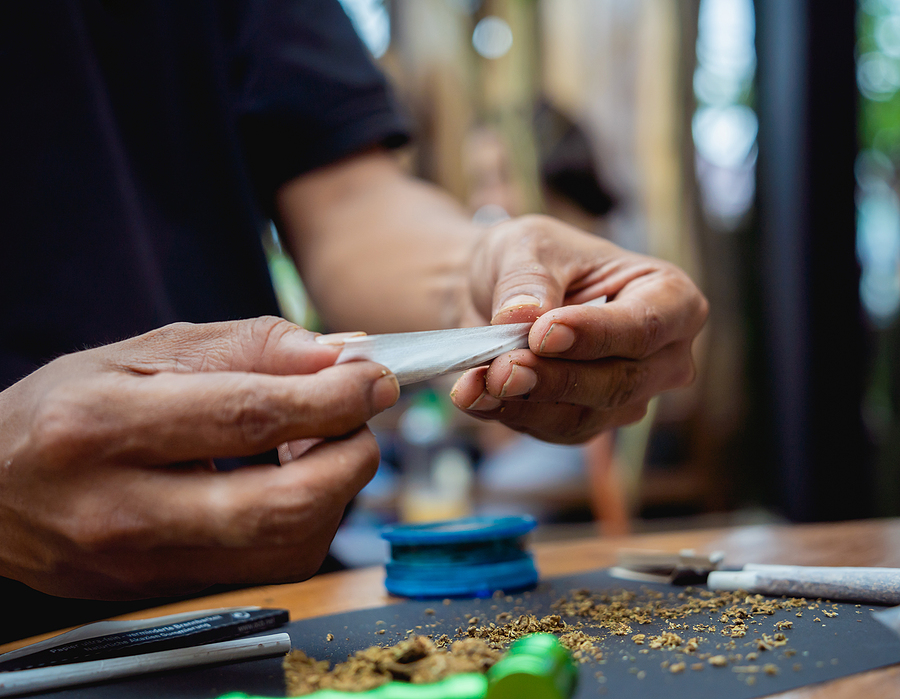 Young Man Making Cigarettes With Medical Marijuana